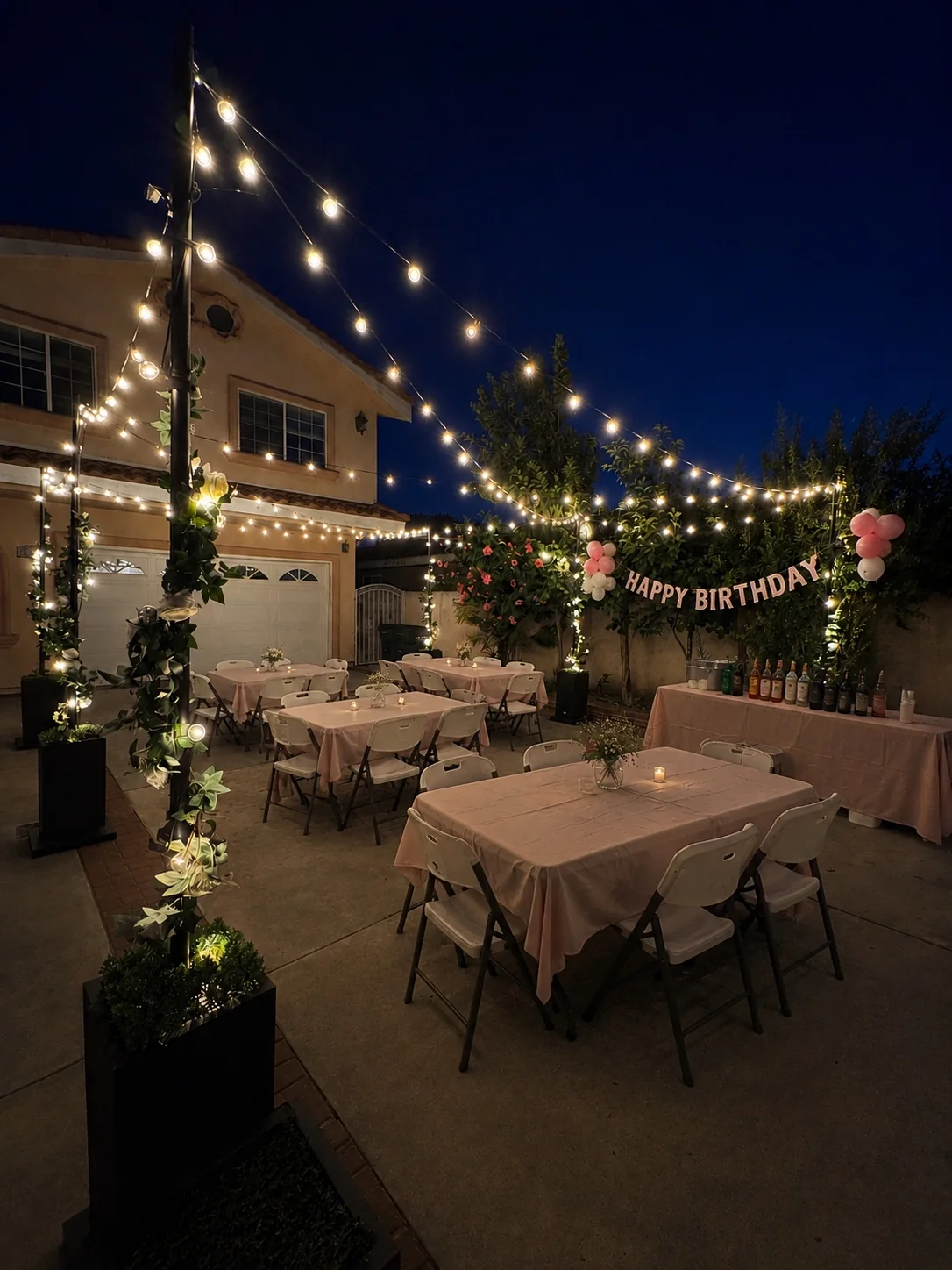 Birthday party tables illuminated by warm café string lights